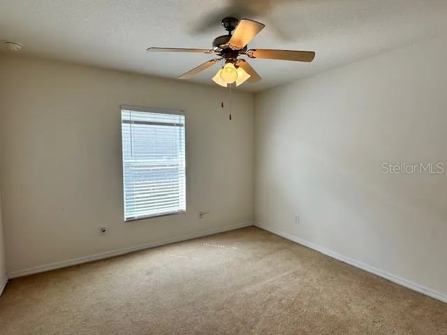 a bathroom with a granite countertop toilet sink and mirror