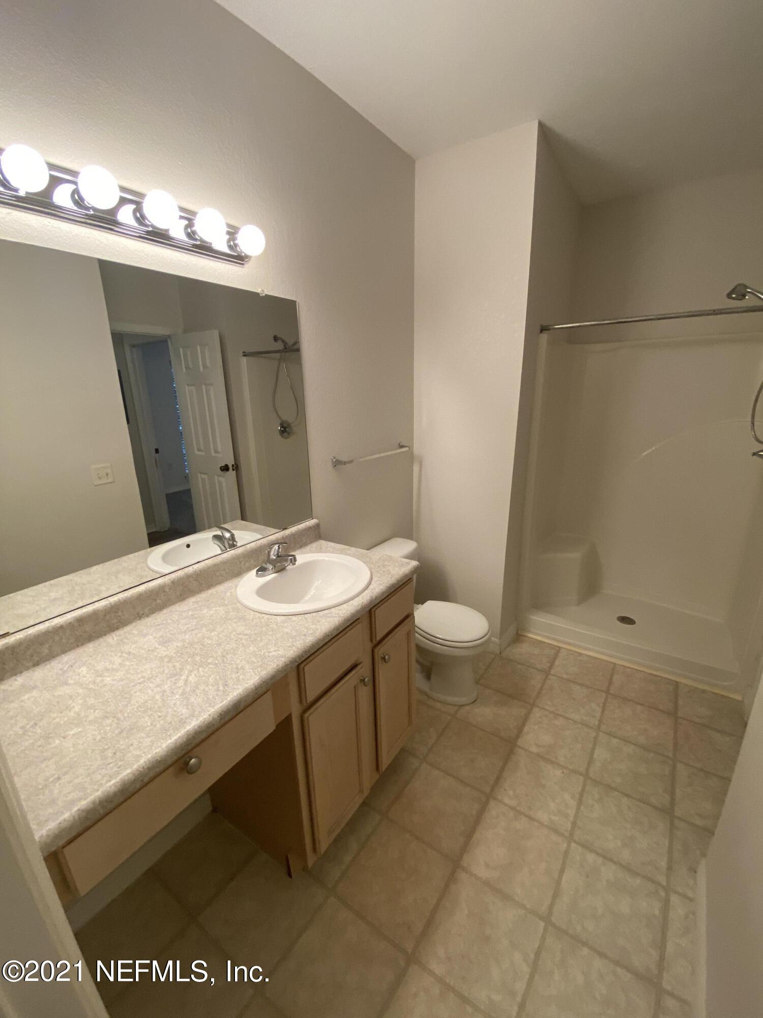 7800 Point Meadows Drive, Unit 422 Jacksonville, FL 32256 - Photo 13 of 38 a bathroom with a sink a toilet and a mirror