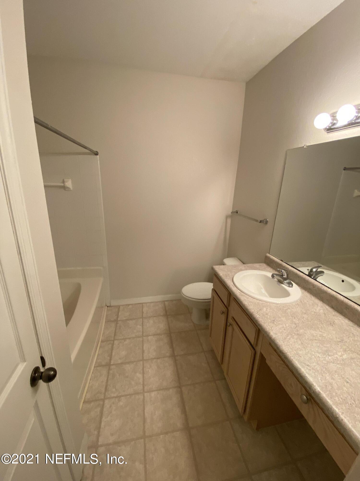 7800 Point Meadows Drive, Unit 422 Jacksonville, FL 32256 - Photo 19 of 38 a bathroom with a granite countertop sink toilet and shower