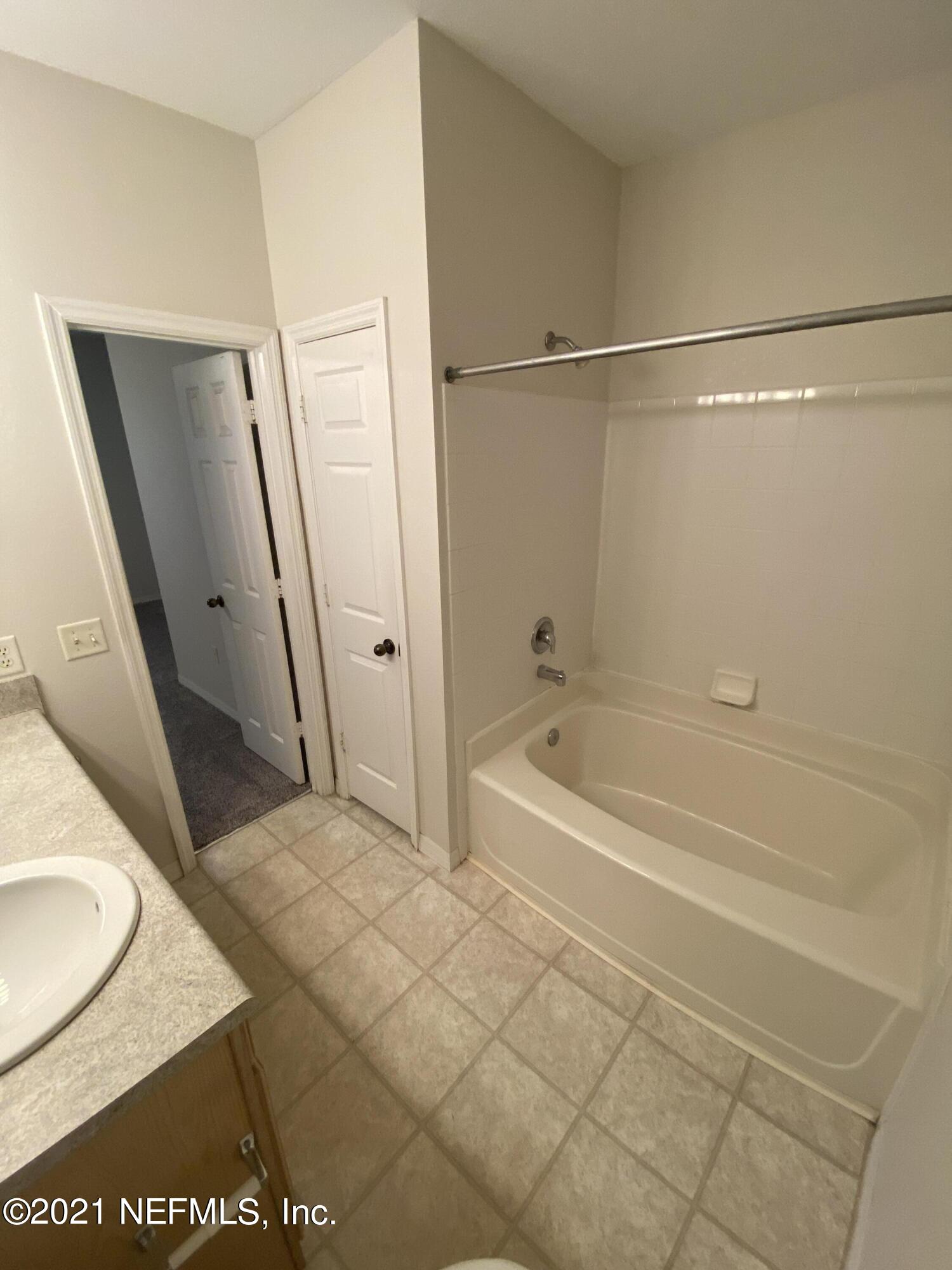 7800 Point Meadows Drive, Unit 422 Jacksonville, FL 32256 - Photo 20 of 38 a bathroom with a tub a sink and a mirror