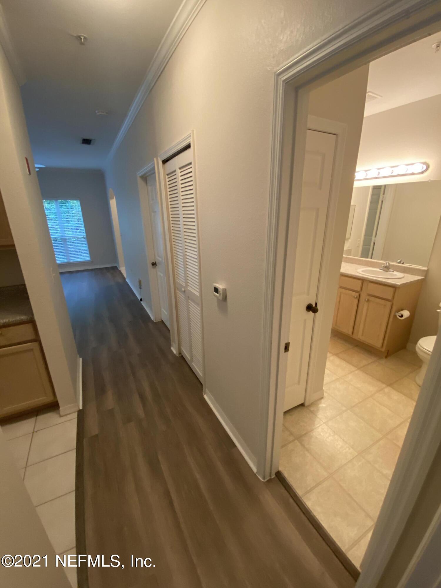 7800 Point Meadows Drive, Unit 422 Jacksonville, FL 32256 - Photo 21 of 38 a view of a hallway with wooden floor and cabinet
