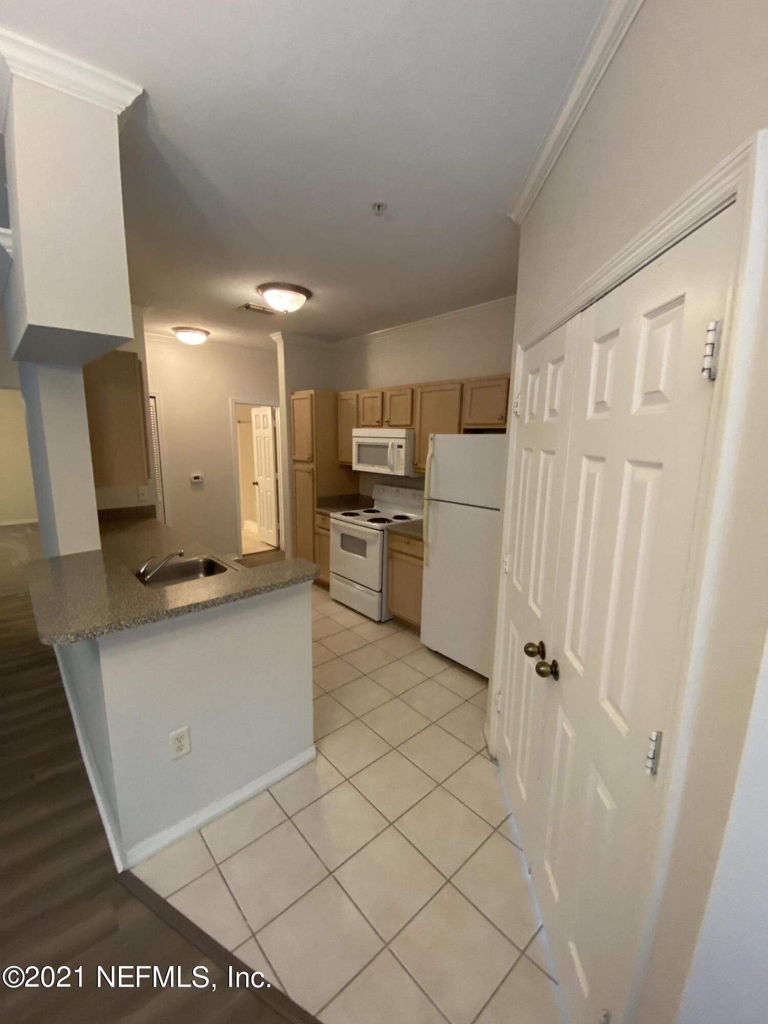 7800 Point Meadows Drive, Unit 422 Jacksonville, FL 32256 - Photo 27 of 38 a kitchen with white cabinets and counter space