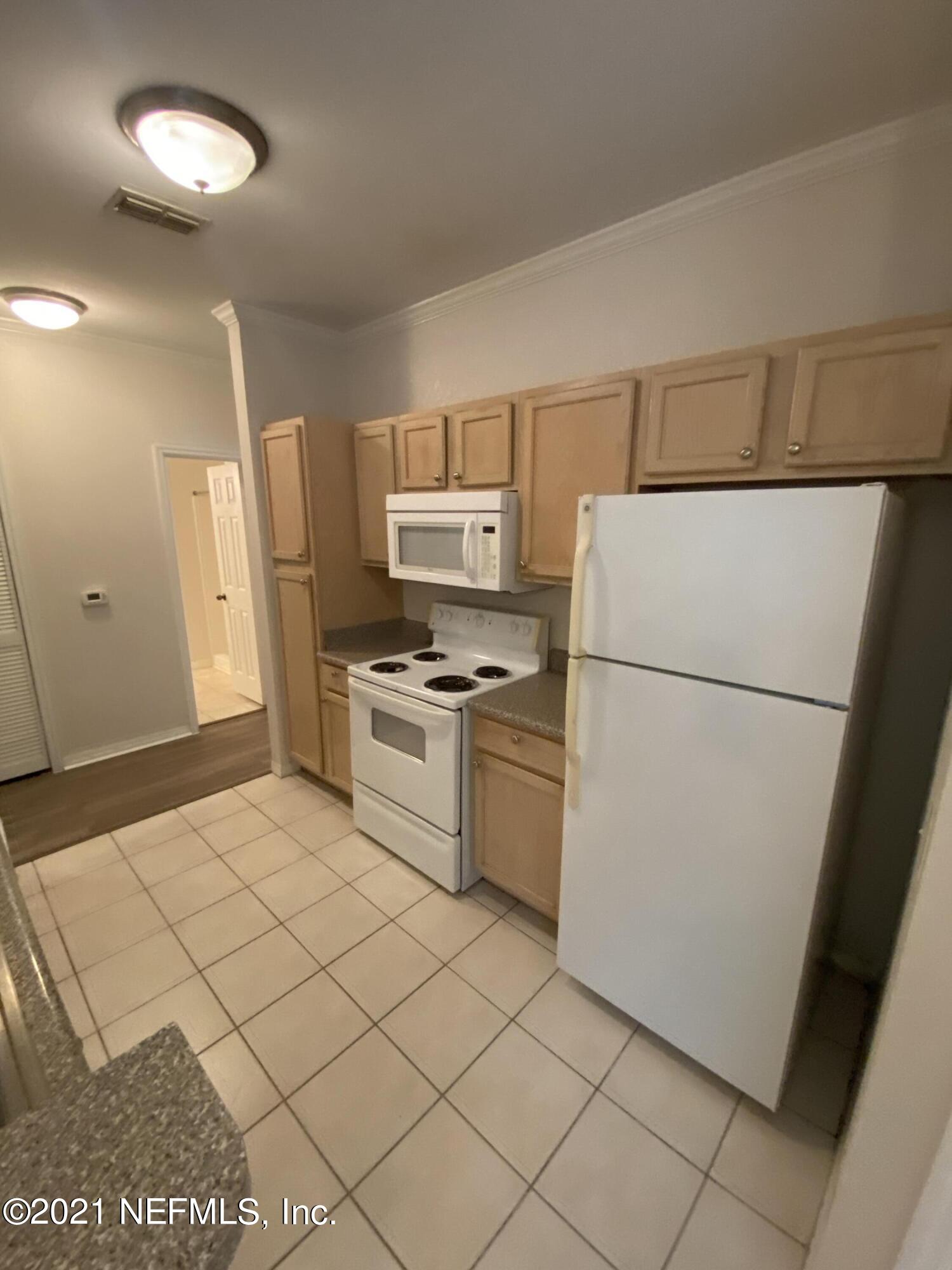 7800 Point Meadows Drive, Unit 422 Jacksonville, FL 32256 - Photo 30 of 38 a kitchen with a refrigerator sink stove and cabinets