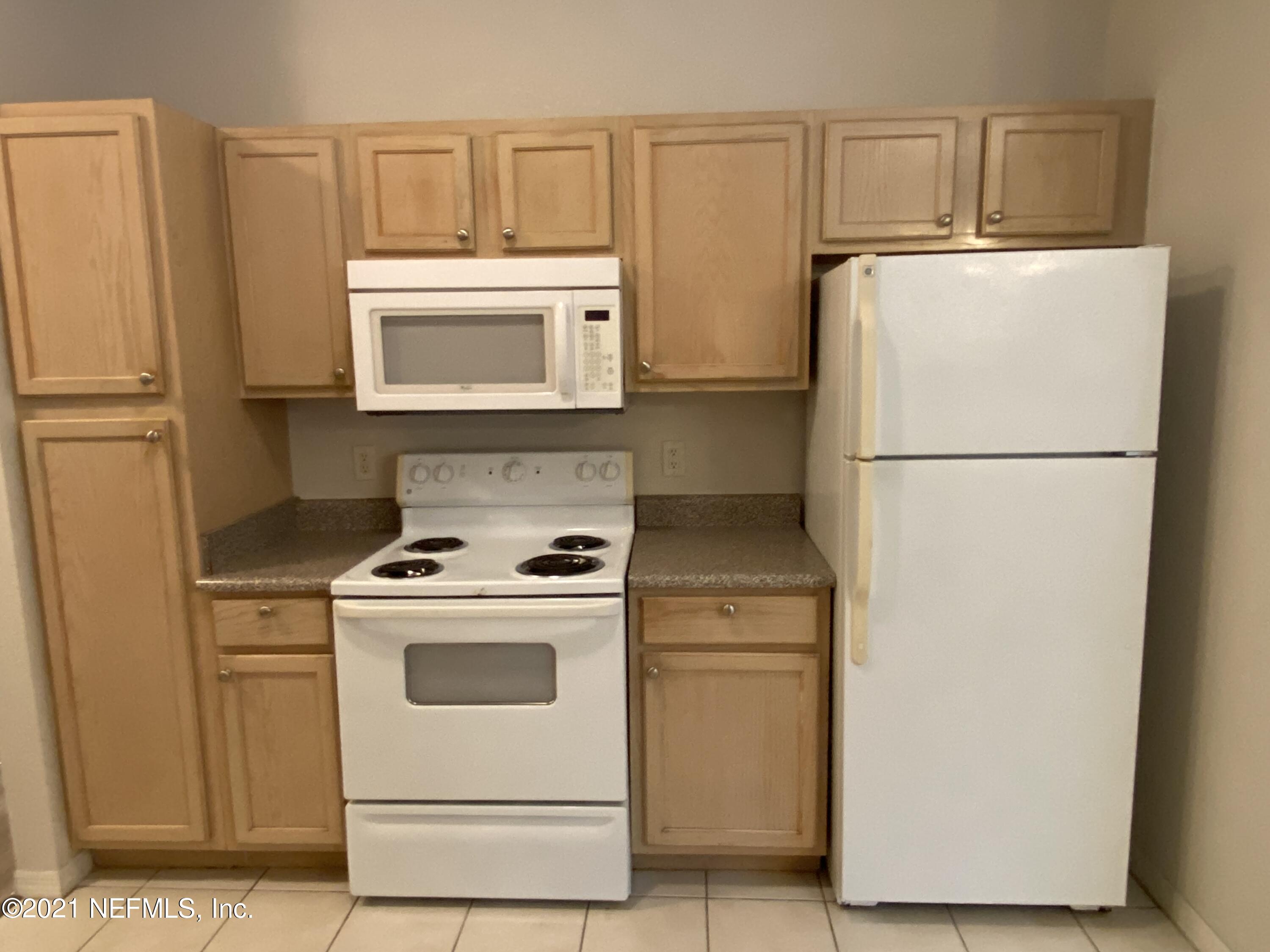 7800 Point Meadows Drive, Unit 422 Jacksonville, FL 32256 - Photo 31 of 38 a white refrigerator freezer and a stove sitting inside of a kitchen