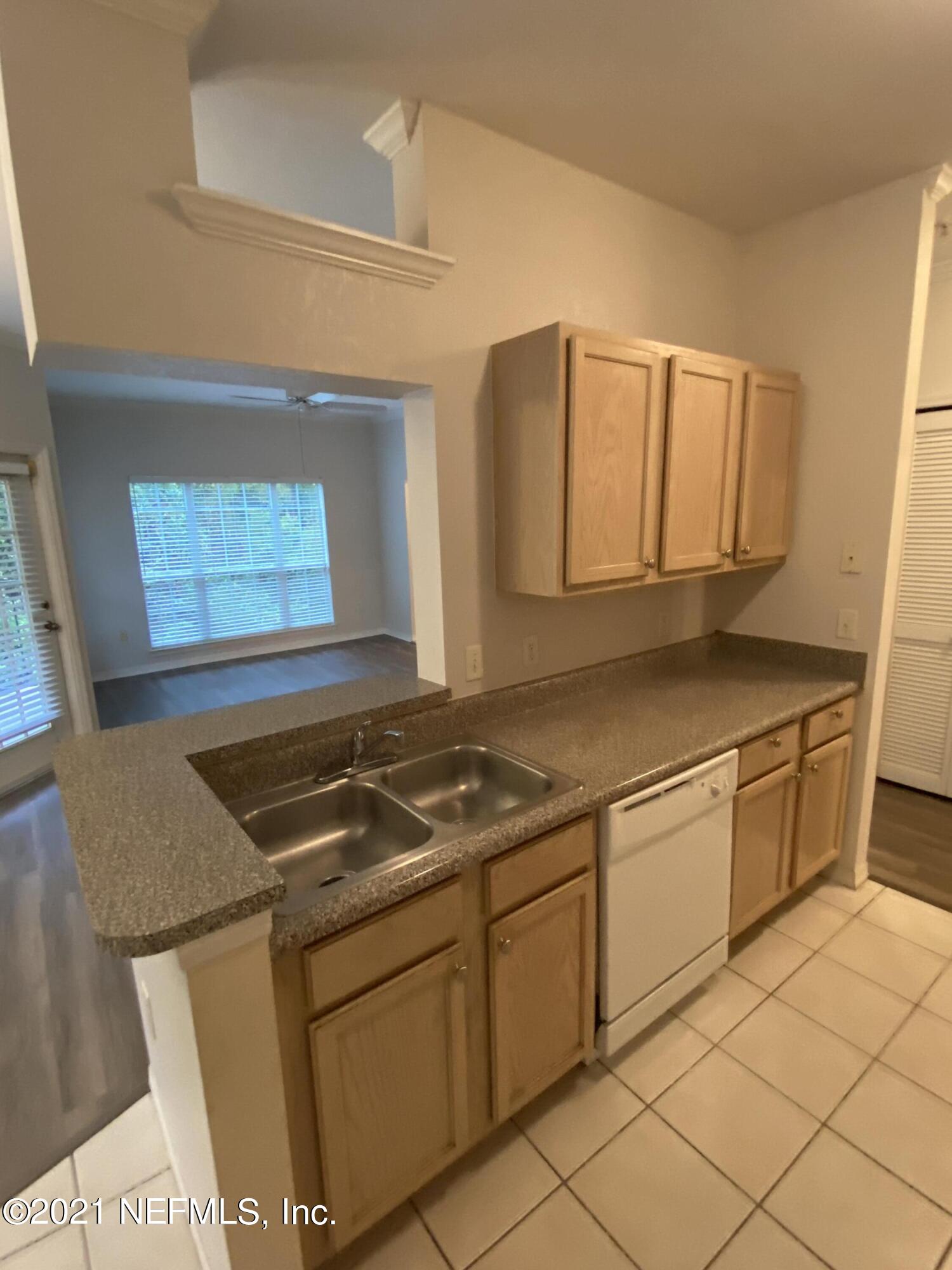 7800 Point Meadows Drive, Unit 422 Jacksonville, FL 32256 - Photo 32 of 38 a kitchen with granite countertop a sink stove and cabinets