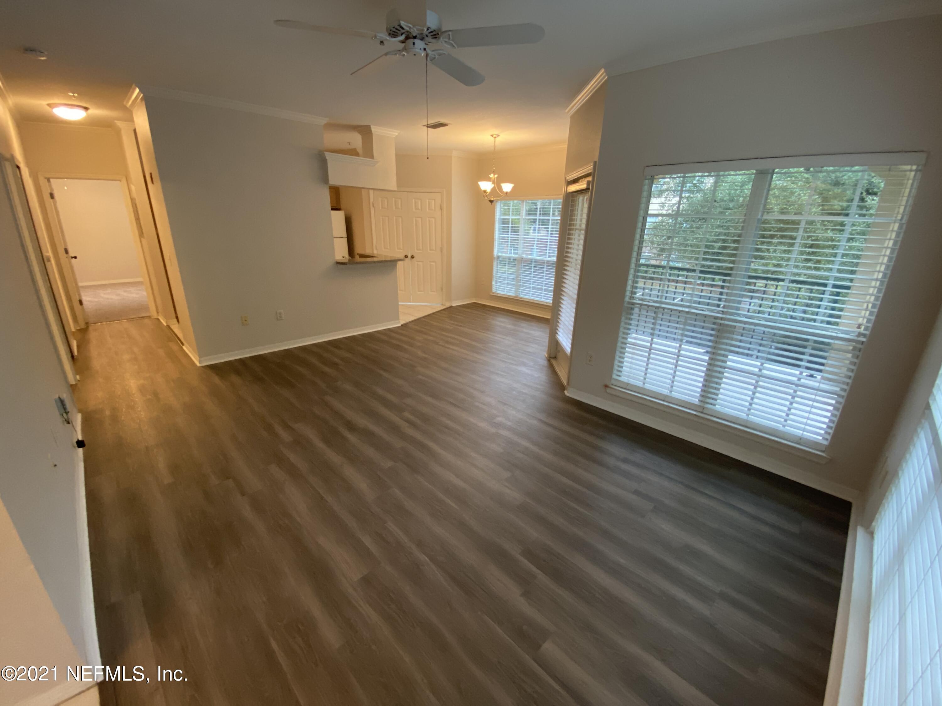 7800 Point Meadows Drive, Unit 422 Jacksonville, FL 32256 - Photo 6 of 38 an empty room with wooden floor and windows