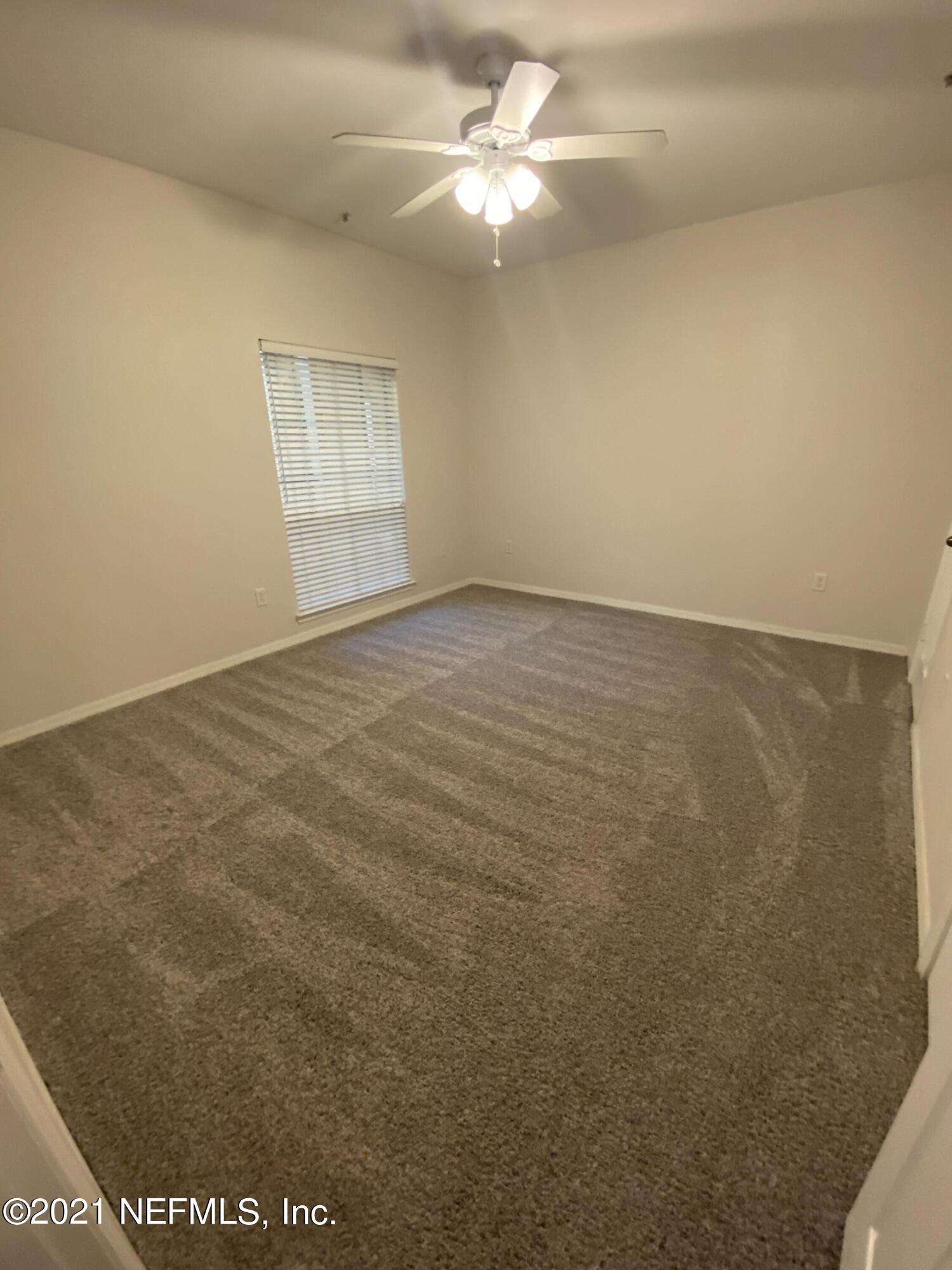 7800 Point Meadows Drive, Unit 422 Jacksonville, FL 32256 - Photo 9 of 38 en empty room with windows and ceiling fan view