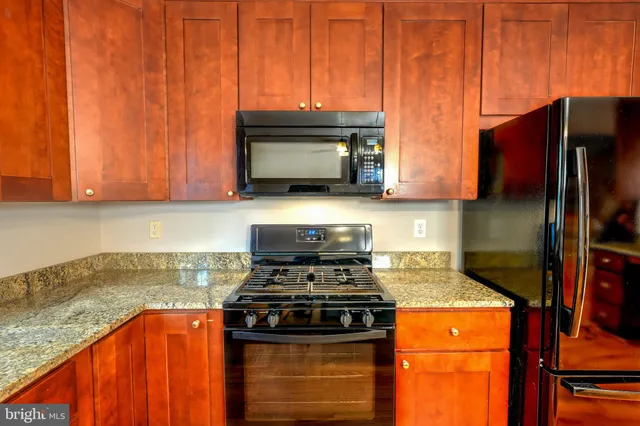a kitchen with stainless steel appliances granite countertop a stove a microwave and a refrigerator