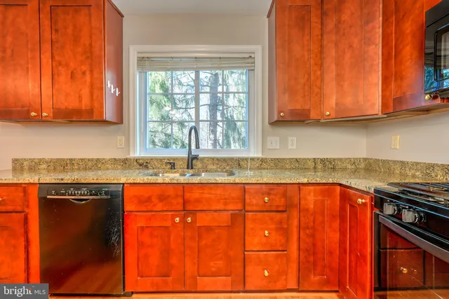 a kitchen with stainless steel appliances granite countertop a sink stove and cabinets