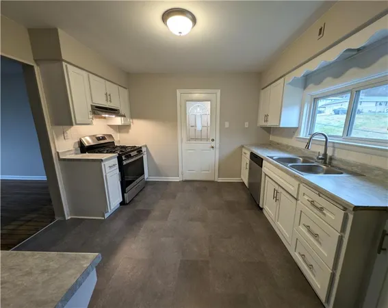 a kitchen with a sink stove and cabinets