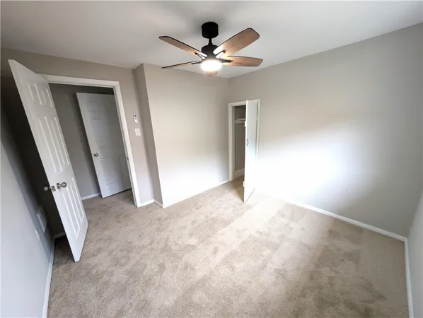an empty room with a window and a fan