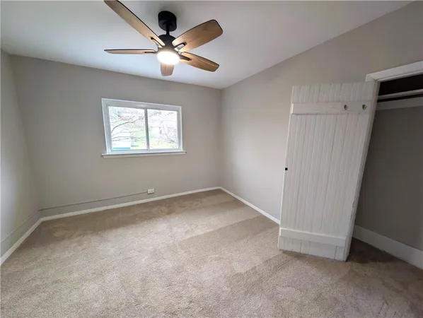 a view of an empty room with a chandelier fan