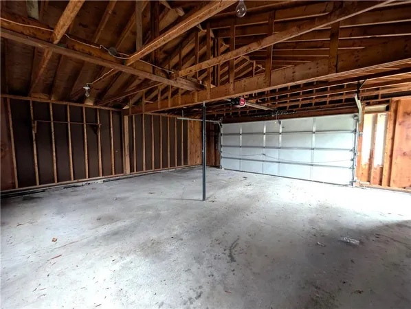 an empty room with wooden floor fireplace and windows