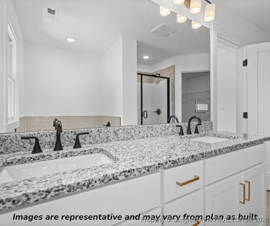 9790 Rockfish Road Raeford, NC 28376 - Photo 3 of 8 a bathroom with a granite countertop sink and a mirror
