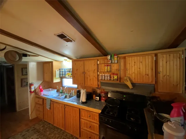 a kitchen with sink refrigerator and cabinets