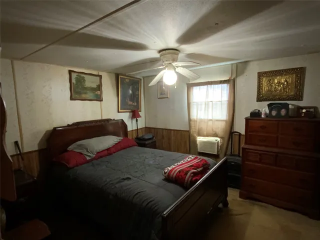a bedroom with a bed dresser and wooden floor