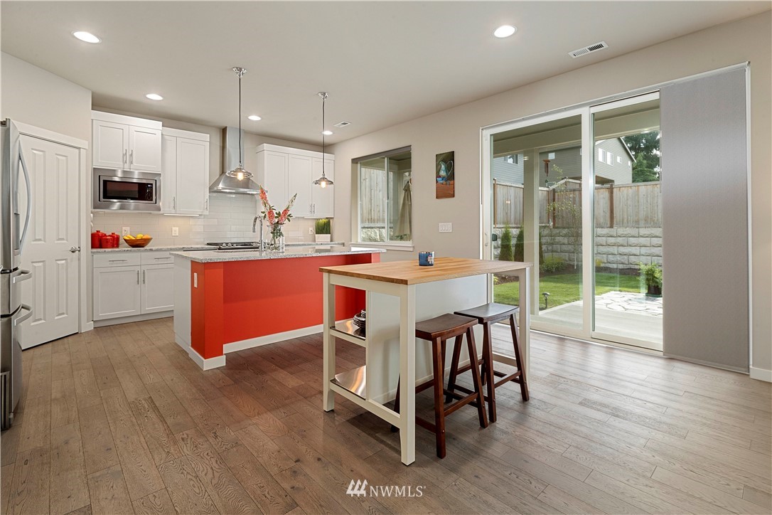 17512 Meridian Place West Bothell, WA 98012 - Photo 5 of 28 a kitchen with stainless steel appliances a dining table chairs and wooden floor