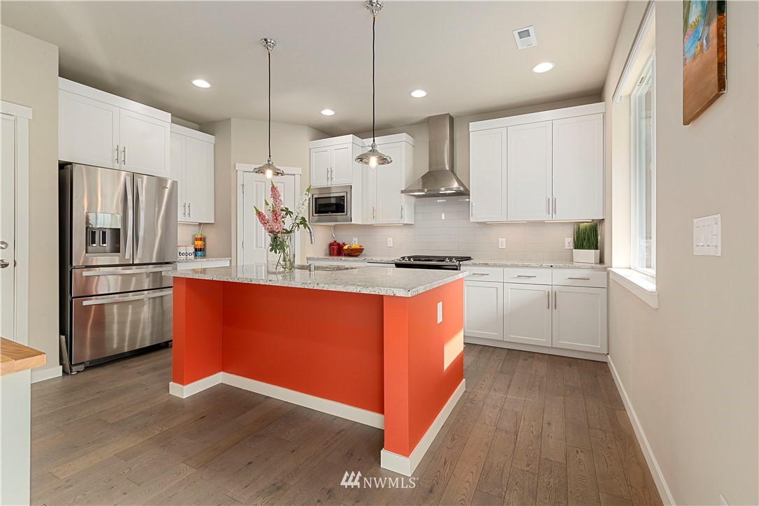 17512 Meridian Place West Bothell, WA 98012 - Photo 6 of 28 a large kitchen with stainless steel appliances kitchen island granite countertop a stove a sink a refrigerator and white cabinets