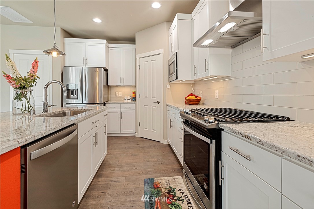 17512 Meridian Place West Bothell, WA 98012 - Photo 7 of 28 a kitchen with stainless steel appliances granite countertop a sink stove and refrigerator