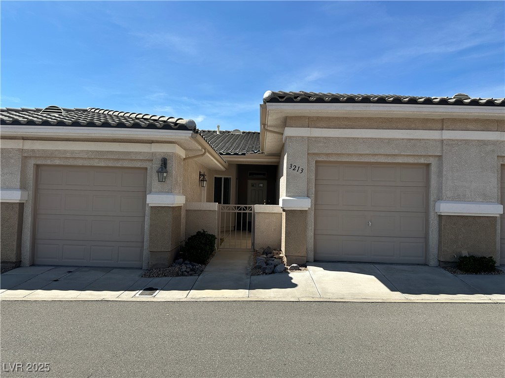 3213 Partridge Run Street Laughlin, NV 89029 - Photo 2 of 37 Townhome / multi-family property with a gate, fence, an attached garage, stucco siding, and a tile roof