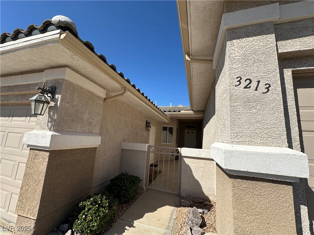 3213 Partridge Run Street Laughlin, NV 89029 - Photo 3 of 37 Entrance to property with stucco siding, a tile roof, a gate, fence, and a garage