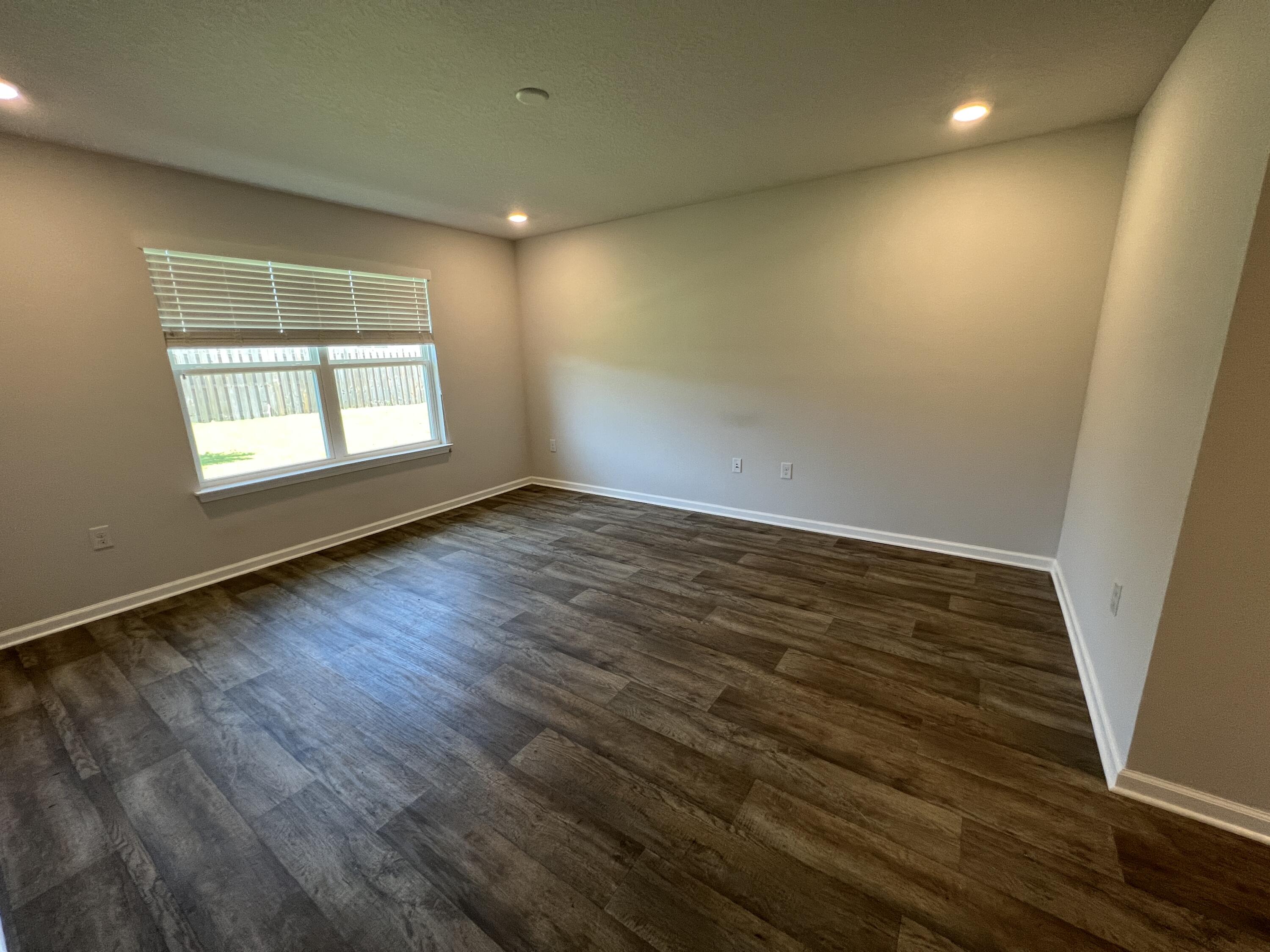 399 This Way Freeport, FL 32439 - Photo 12 of 29 an empty room with wooden floor and windows