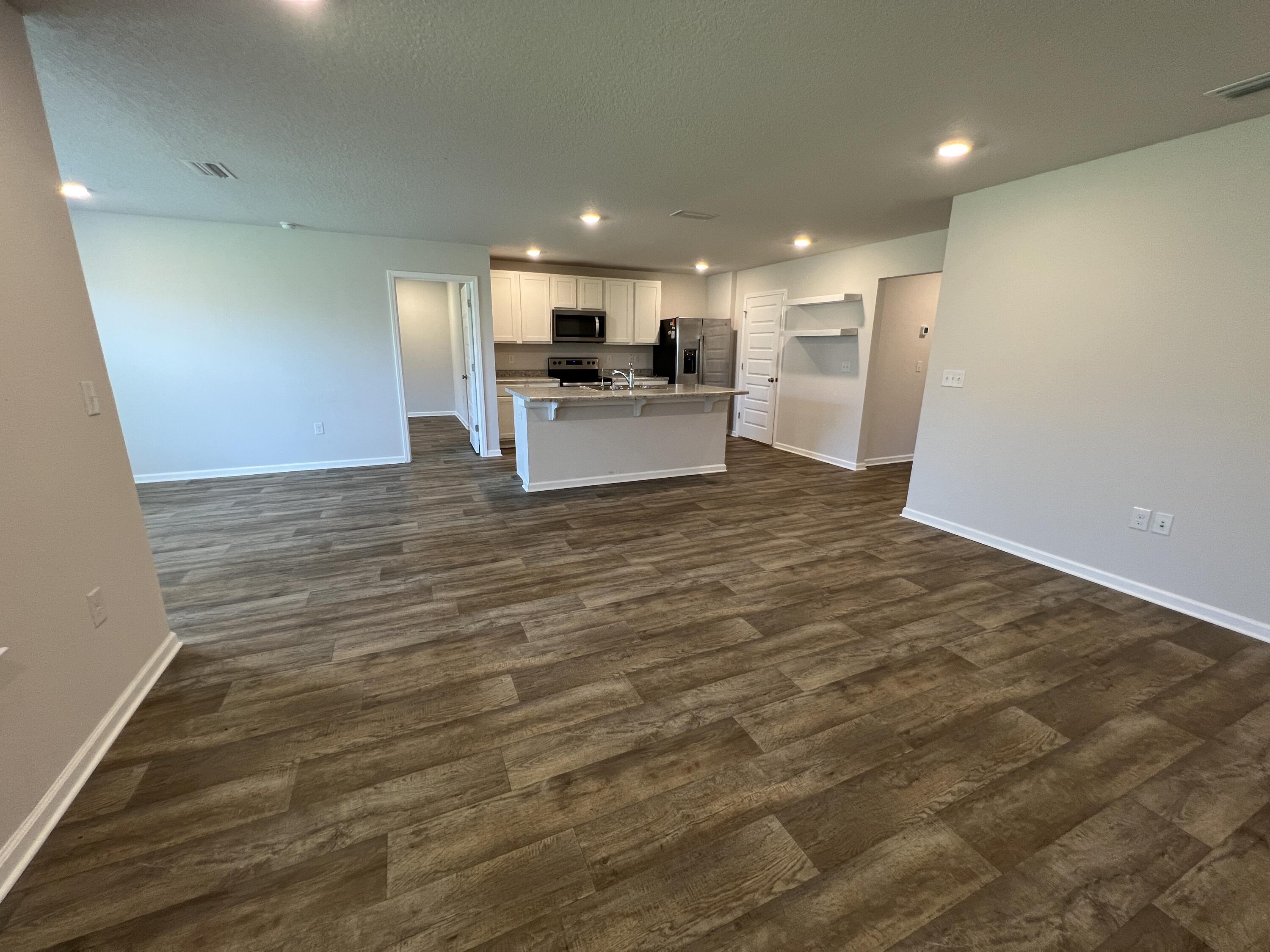 399 This Way Freeport, FL 32439 - Photo 4 of 29 a view of kitchen with kitchen island microwave and refrigerator