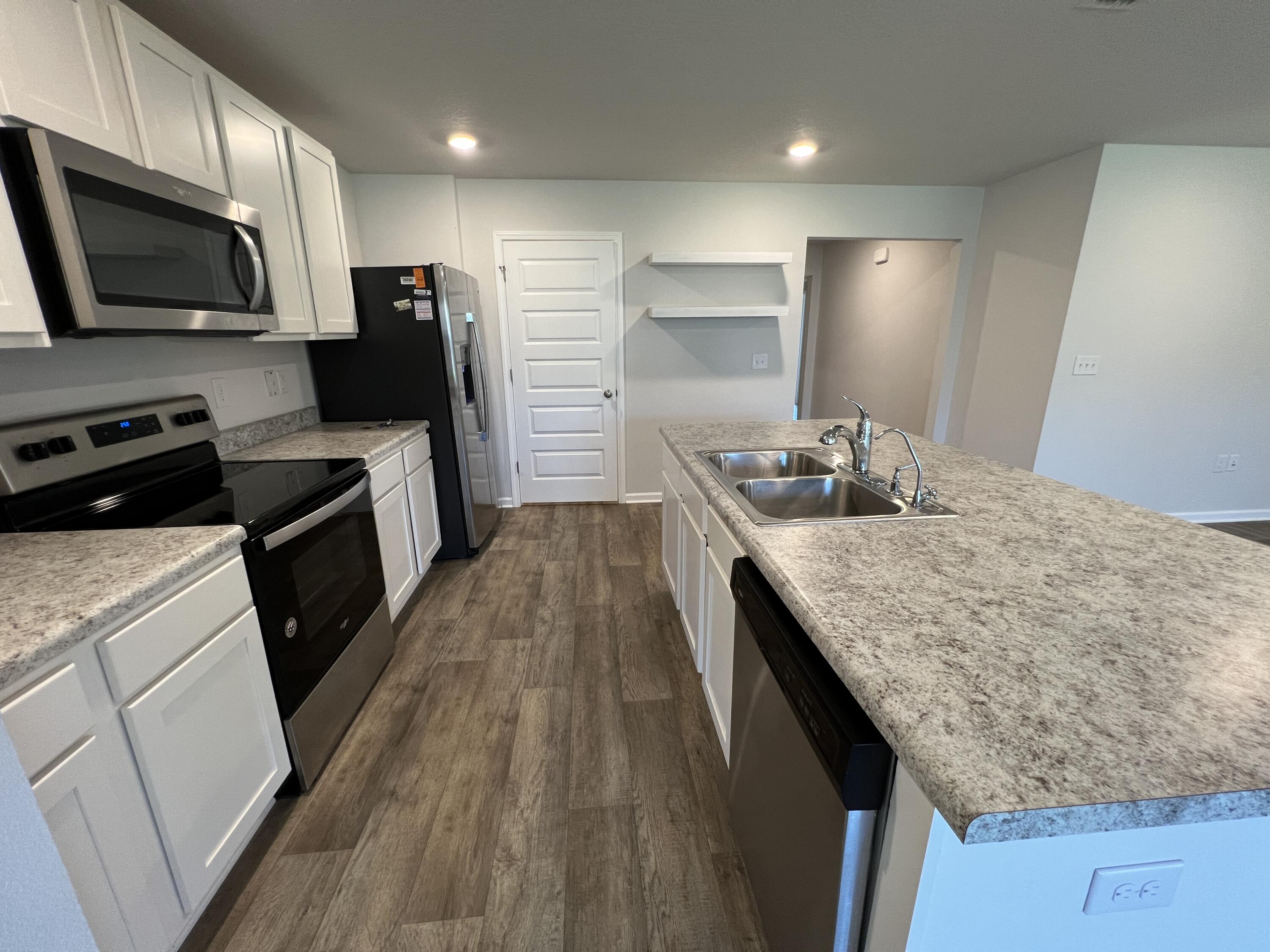 399 This Way Freeport, FL 32439 - Photo 6 of 29 a kitchen with granite countertop sink stainless steel appliances and wooden cabinets