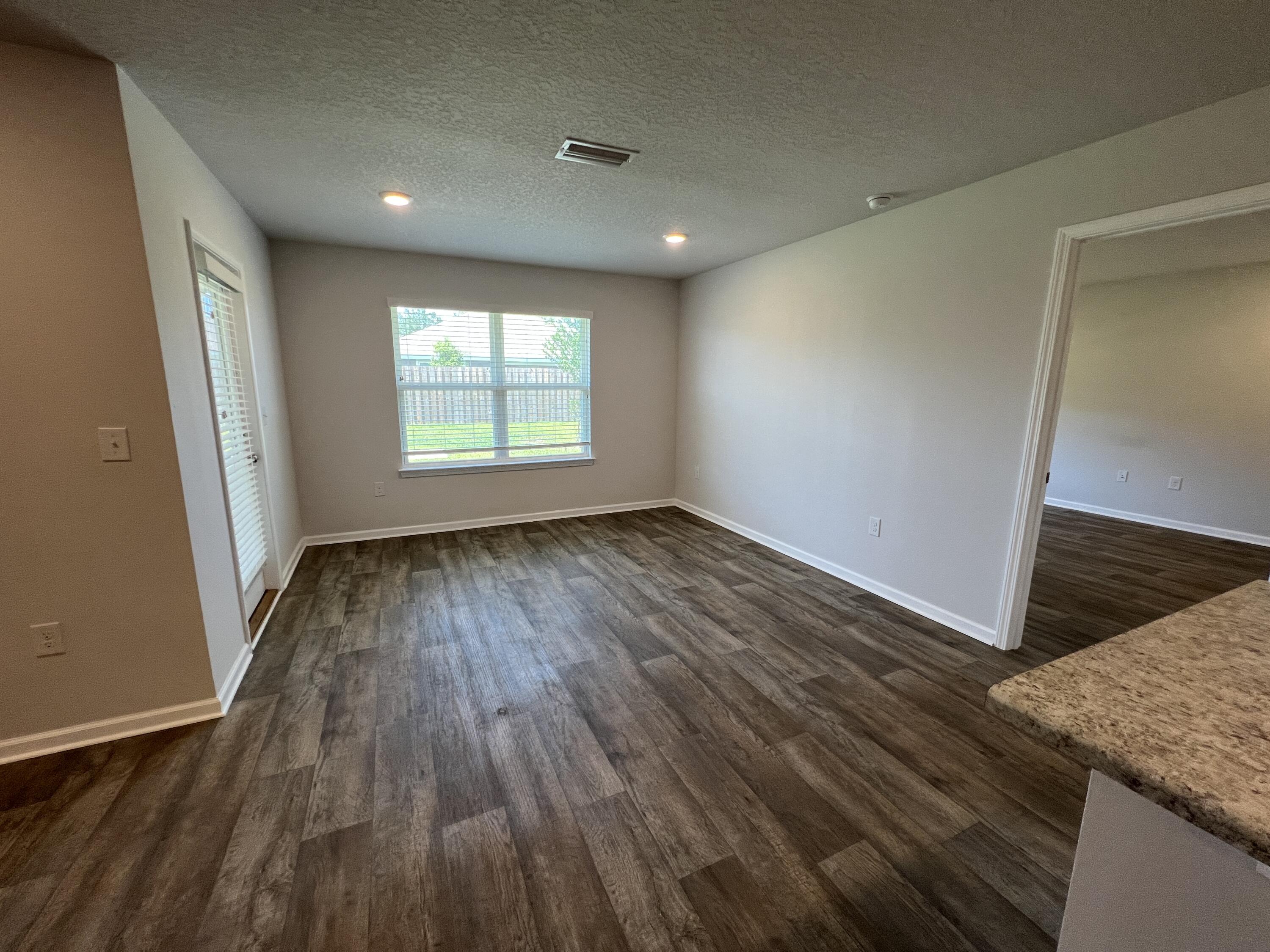 399 This Way Freeport, FL 32439 - Photo 7 of 29 an empty room with wooden floor and windows