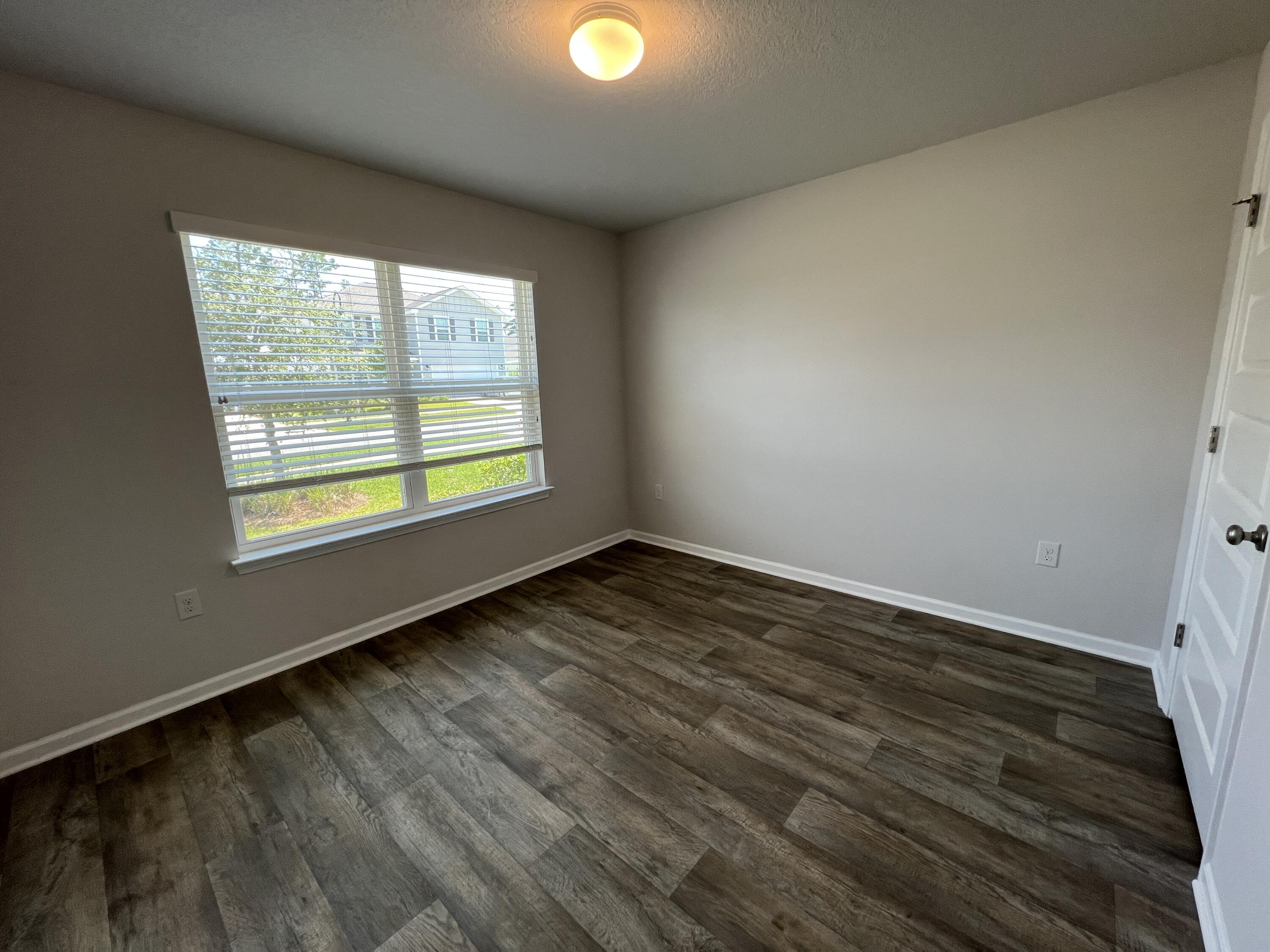 399 This Way Freeport, FL 32439 - Photo 8 of 29 a view of an empty room with wooden floor and a window