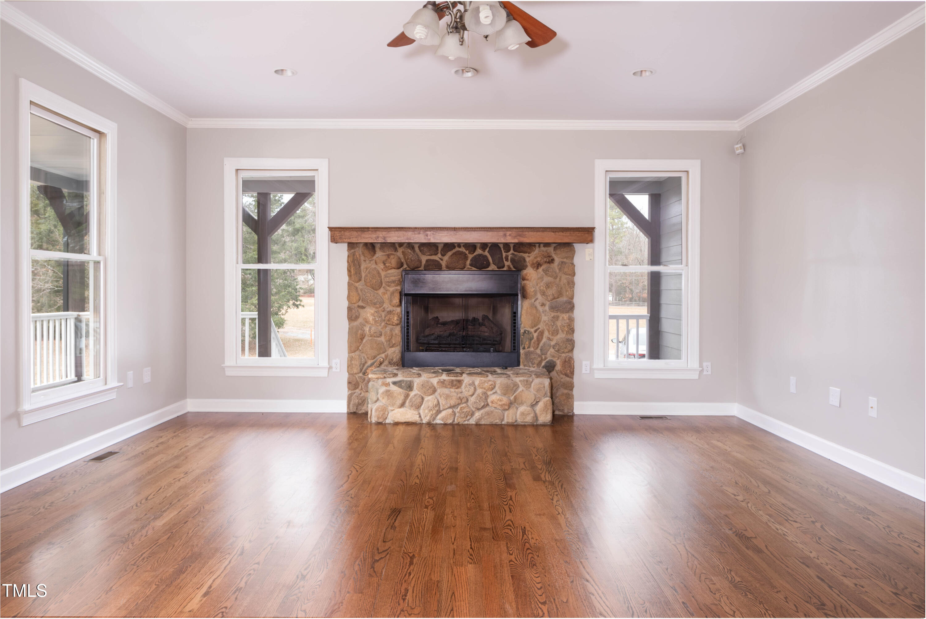 4222 Rogers Road Durham, NC 27703 - Photo 5 of 84 an empty room with wooden floor a fireplace and windows