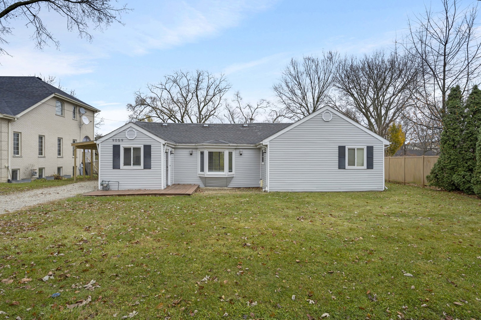 a view of a yard in front of a house with large trees