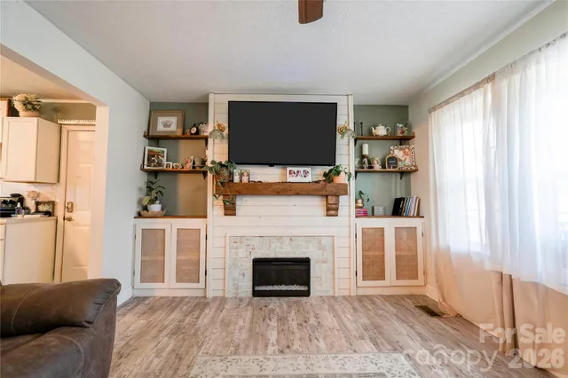 a living room with furniture a flat screen tv and a fireplace