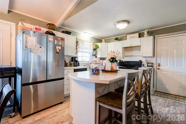 a kitchen with stainless steel appliances a refrigerator a stove a sink dishwasher and a refrigerator with wooden floor