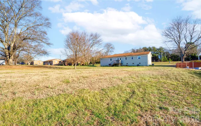 a view of residential houses with yard and trees