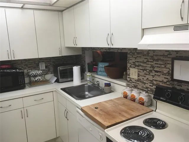 a kitchen with sink cabinets and stove top oven