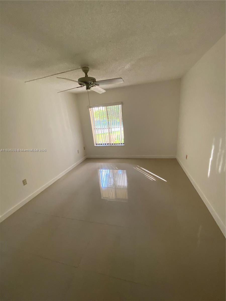8015 Southwest 107th Avenue, Unit 209 Miami, FL 33173 - Photo 30 of 43 an empty room with windows and fan