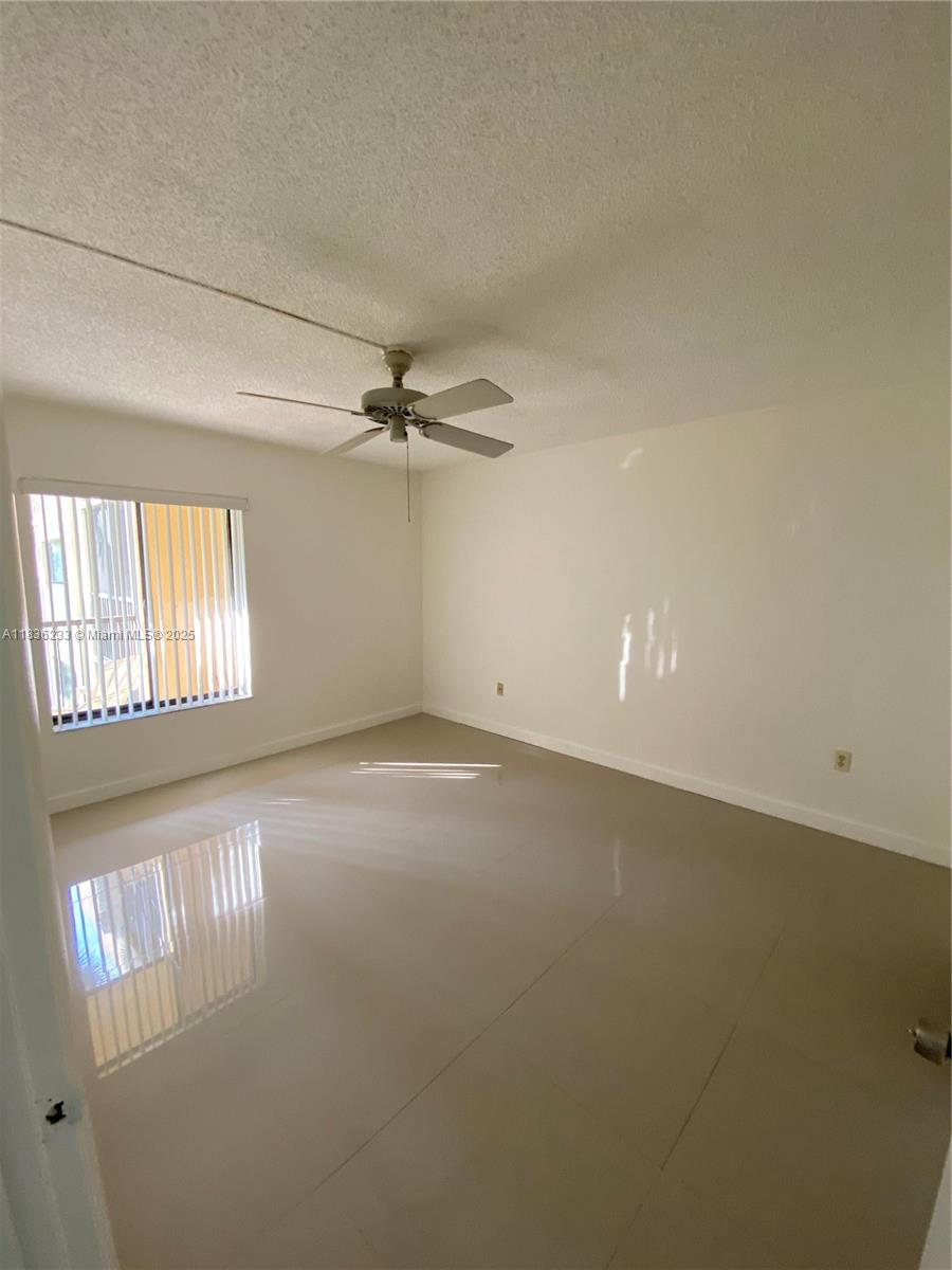8015 Southwest 107th Avenue, Unit 209 Miami, FL 33173 - Photo 4 of 43 en empty room with windows and ceiling fan view