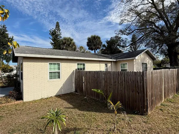 a view of house with backyard and sitting area