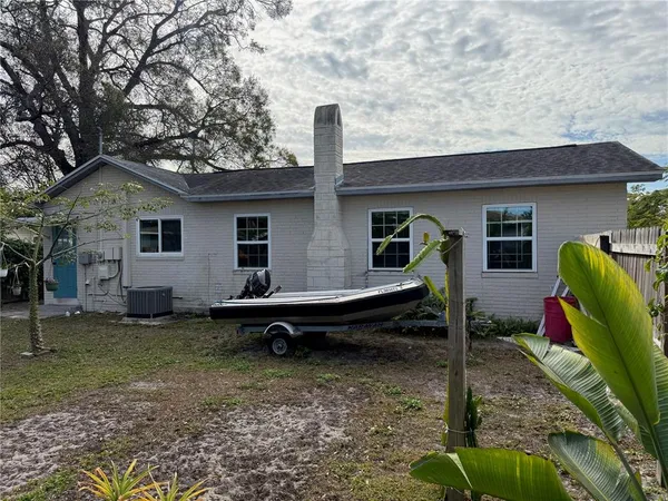 a backyard of a house with barbeque oven table and chairs