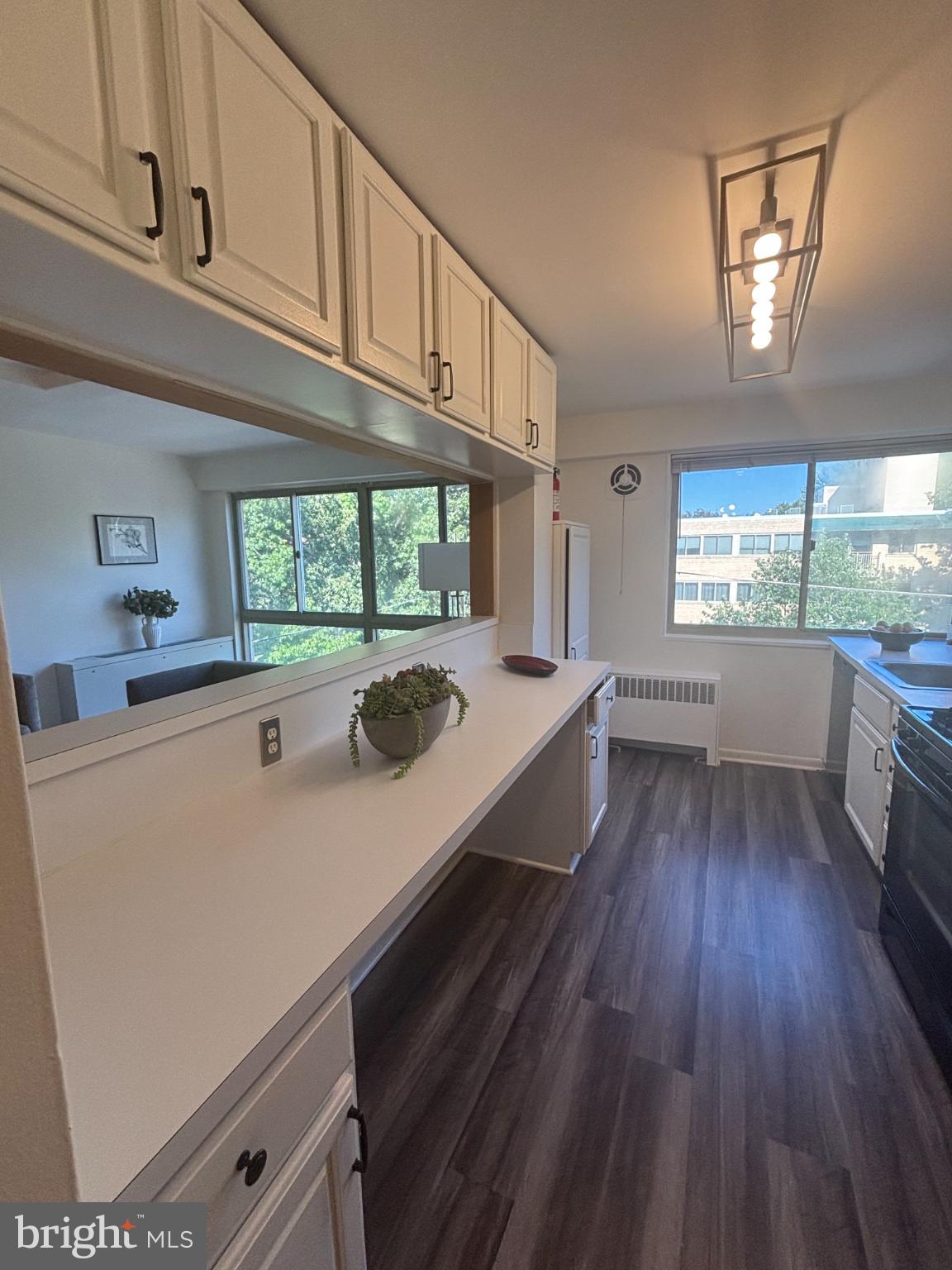 6445 Luzon Avenue Northwest, Unit 501 Washington, DC 20012 - Photo 3 of 21 a kitchen with kitchen island wooden floors and stainless steel appliances