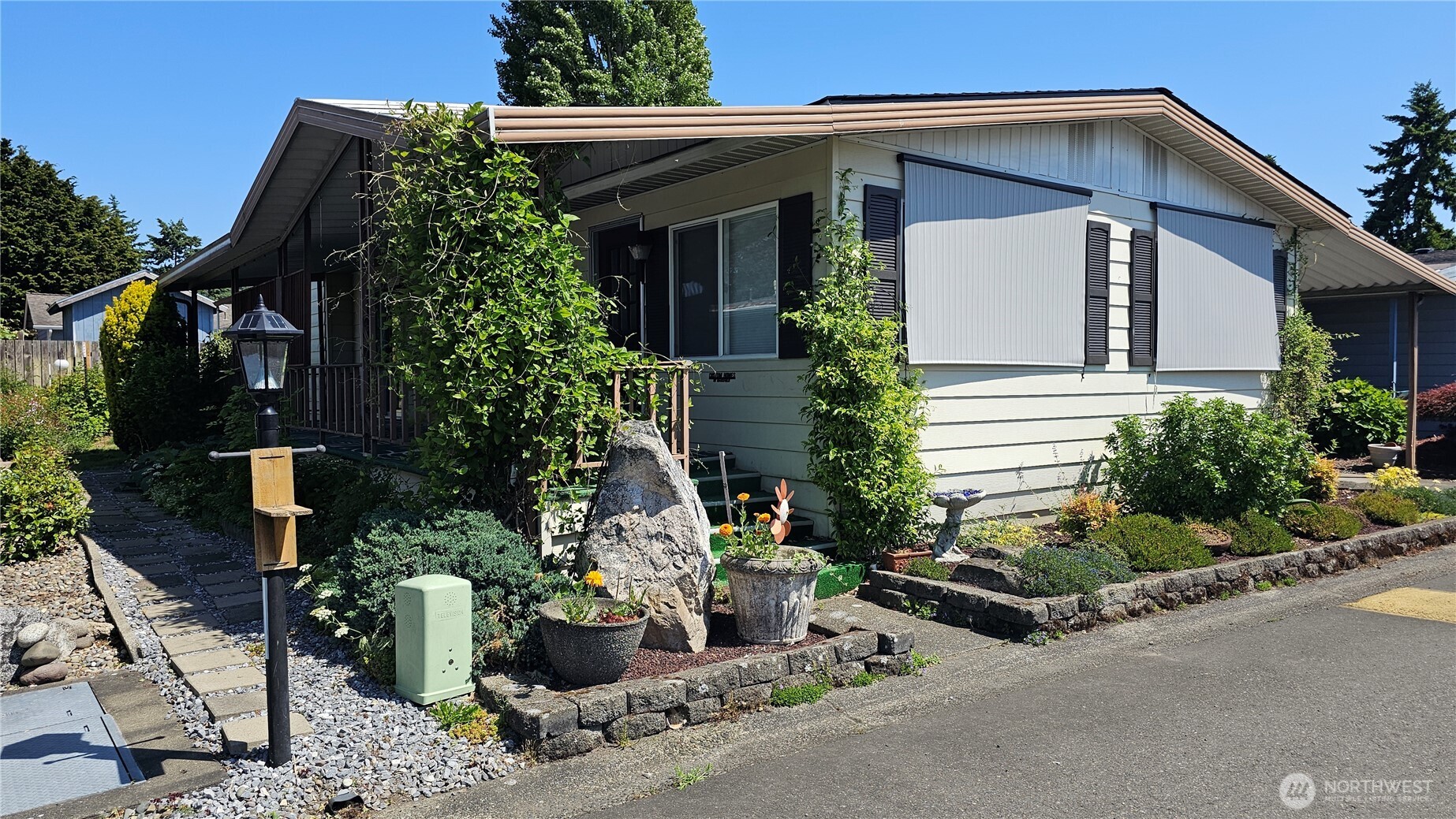 a view of a house with potted plants and a bench