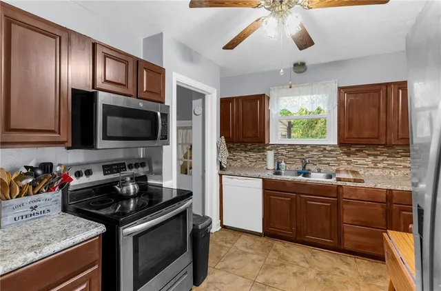 a kitchen with stainless steel appliances granite countertop a sink and a stove