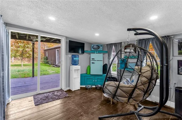 a view of an entryway with wooden floor windows and a garden