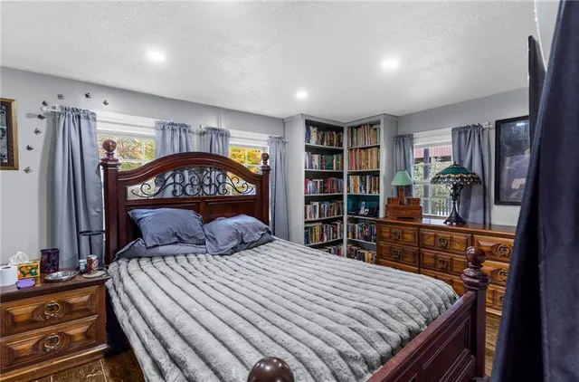 a bedroom with a bed a window and book shelf
