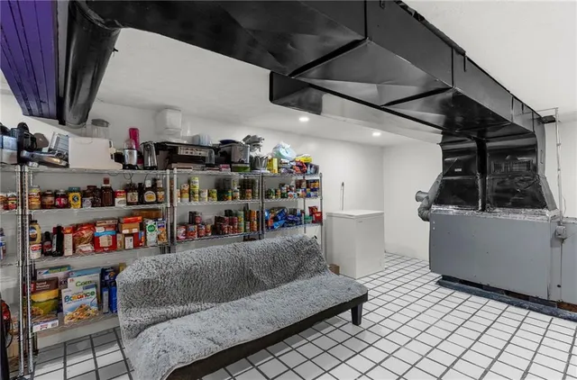 a living room with lots of furniture and a refrigerator