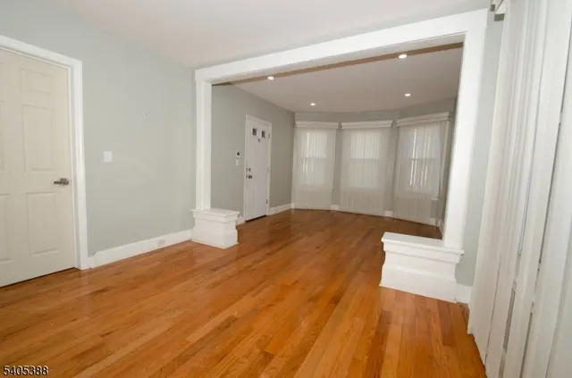 a view of a big room with wooden floor and windows