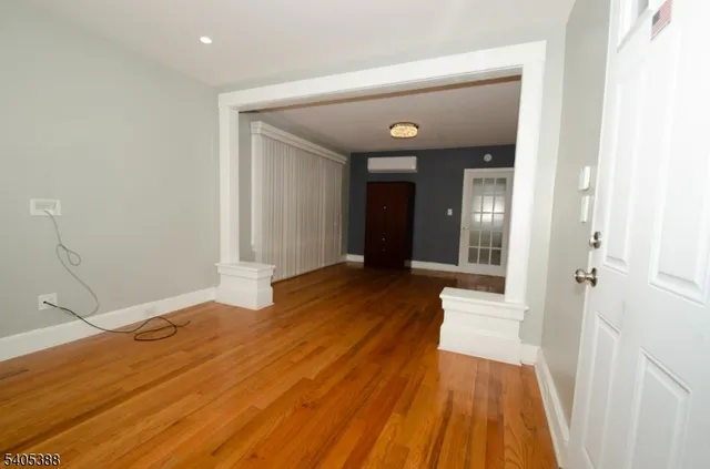 a view of a room with wooden floor and a bathroom