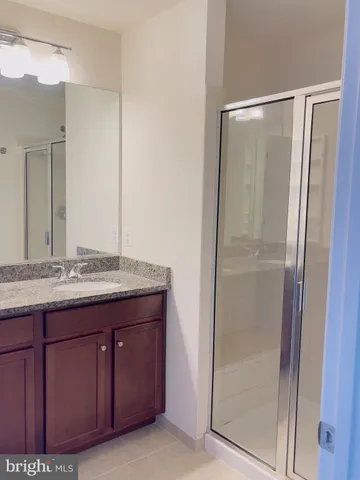 a bathroom with a granite countertop sink and shower