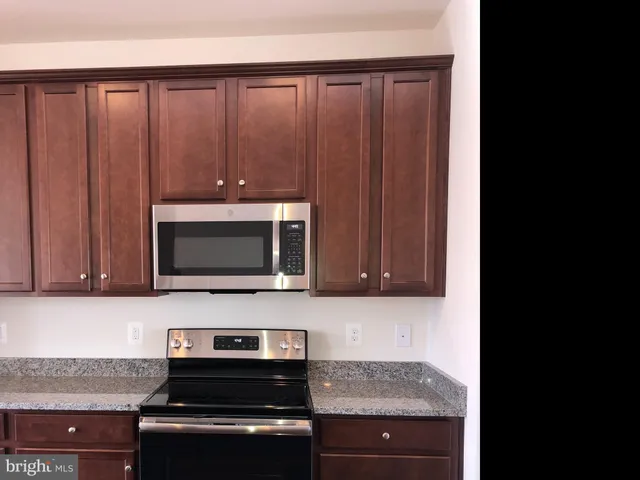 a kitchen with wooden cabinets and a stove top oven